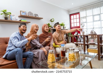 muslim friend sitting in livingroom enjoy watching tv