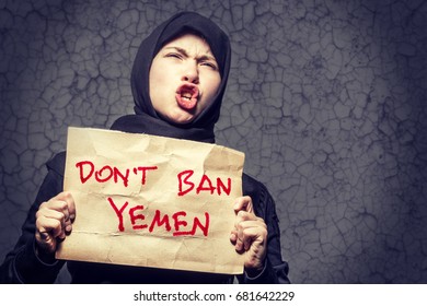 Muslim Girl In Black Hijab Holding A Poster With An Inscription DON'T BAN YEMEN On The Background Wall With Cracks