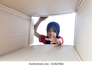 Muslim Girl Reaching For Something Inside The Box