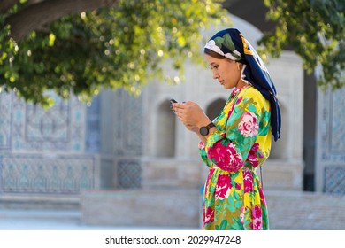 Muslim girl with a scarf on her head at the gate of the old mosque. Bukhara, Uzbekistan