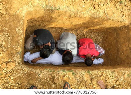 Muslim gravediggers preparing graveyard.