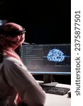 Muslim guy working with code and AI interface on a desktop computer. He is a professional developer managing data on a networked server in a cloud-based data center.
