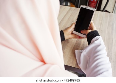 Muslim Hijab Women Using A Phone. Over The Shoulder View. 