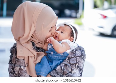 Muslim Indonesian family mom and child concept. Young Asian Muslim Mother and her daughter child girl smiling,hugging and kissing together              