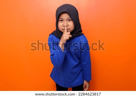 Muslim kid gesturing to maintain silence