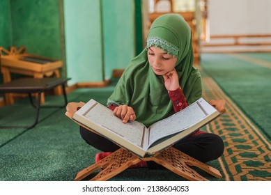 A Muslim kid girl learning a holy book Quran inside the Mosque.	 - Powered by Shutterstock