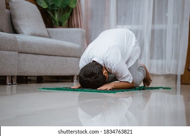 Muslim Kid Prostrating In Praying On The Prayer Mat In The House