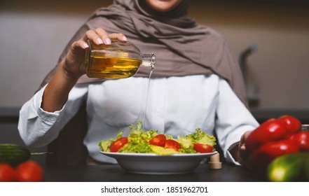 Muslim Lady Cooking Drizzling Olive Oil On Vegetable Salad Preparing Healthy Dinner In Modern Kitchen At Home, Wearing Hijab. Arabic Woman Making Meal Indoor. Arab Cuisine Recipes Concept. Cropped