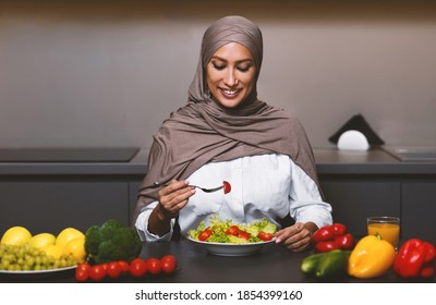 Muslim Lady Eating Fresh Vegetable Salad For Dinner Sitting In Modern Kitchen At Home. Dieting, Healthy Food And Nutrition For Arab Female. Weight Loss Recipes And Dieting Concept - Powered by Shutterstock