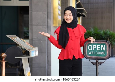 Muslim Lady Standing Outside The Halal Restaurant With Open Sign To Welcome And Greeting The Customer