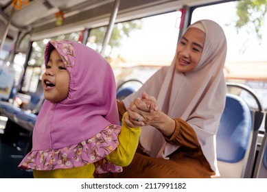 Muslim Little Girl With Hijab Riding Bus Together With Her Mother