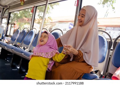 Muslim Little Girl With Hijab Riding Bus Together With Her Mother