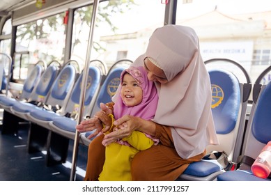 Muslim Little Girl With Hijab Riding Bus Together With Her Mother