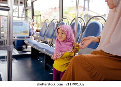 Muslim Little Girl With Hijab Riding Bus Together With Her Mother