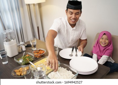 muslim man breaking the fast dinner with his daugther and family at home