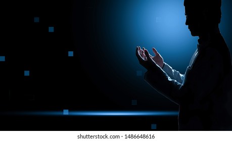 Muslim Man With Fully Traditional Dress Praying For Allah, Muslim God, On Mosque In Ramadan Kareem Night With Blue Background.