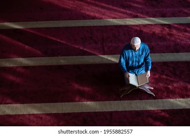 Moslem Mann betet Allahs allein in der Moschee und liest islamitisches Heiligbuch
