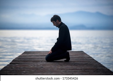 Muslim man praying on an empty dock
