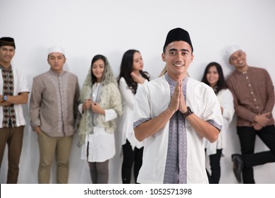 A muslim man standing in front of a group in studio - Shutterstock ID 1052571398
