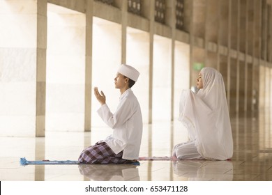 Muslim Man And Woman Praying For Allah In The Mosque Together 