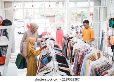 Muslim Mother Choosing Shirt With Daughter During Shopping At Fashion Shop
