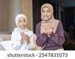 Muslim mother and daughter praying together at home, islamic family values, religious tradition, peaceful worship, hijab women, faith, spirituality, happy bonding, cultural heritage, islamic lifestyle