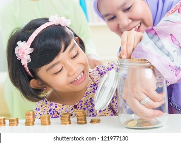 Muslim Mother And Daughter Saving Money At Home. Southeast Asian Family Living Lifestyle.