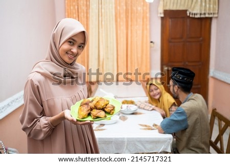 muslim mother serving some food for family dinner