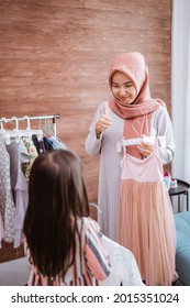 Muslim Mother Shopping With Her Daughter At Boutique Clothing Shop