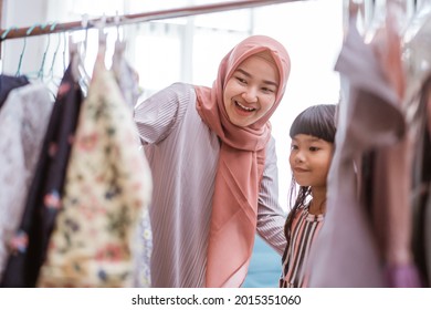 Muslim Mother Shopping With Her Daughter At Boutique Clothing Shop