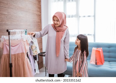 Muslim Mother Shopping With Her Daughter At Boutique Clothing Shop