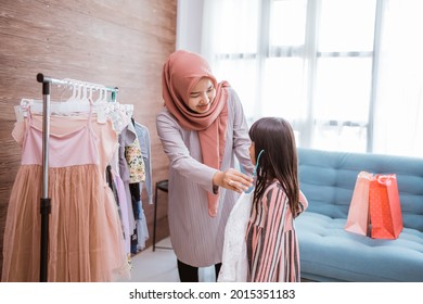 Muslim Mother Shopping With Her Daughter At Boutique Clothing Shop