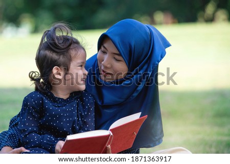 Muslim mother tease her daughter, outdoor activities warm family day at the park