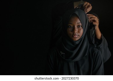 Muslim mothers dress traditional muslim style with Niqab veil for daughter, on black background