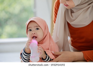 Muslim Newborn Baby Smile With Milk Power Bottle.Muslim Family Mom And Child Concept Domestic Life.
