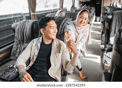 muslim passengers sharing snacks with other during their road trip on the bus - Powered by Shutterstock