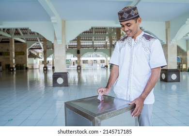 Muslim Paying Some Zakat Charity Using Cash At The Mosque