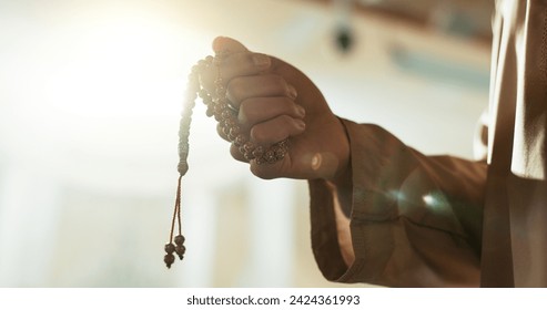 Muslim, prayer beads and hand of man in mosque with tasbih for spiritual, meditation and mindfulness in religion. Counting, dhikr and person praying in Islam, faith with hope in God in the morning - Powered by Shutterstock