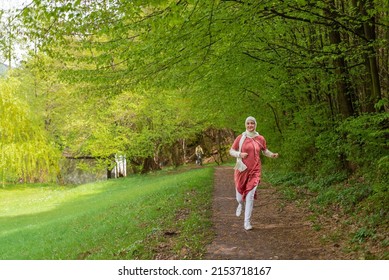 Muslim sports woman trail running throw path in the spring forest. Healthy lifestyle wellbeing. Fit girl in hijab jogging outdoor. - Powered by Shutterstock