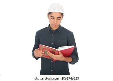 Muslim Teenager Wearing A Hat And Reading Quran, Isolated On White Background, Translation Of The Text: Holy Quran