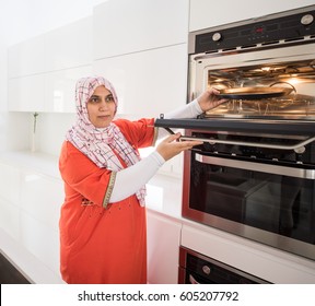 Muslim traditional woman using stove - Powered by Shutterstock