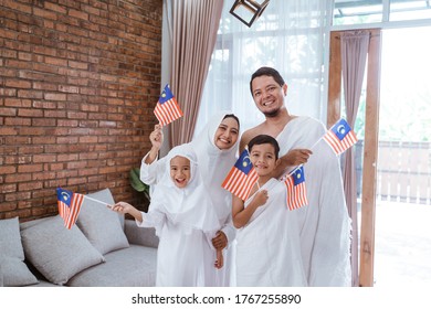 Muslim Umrah And Hajj With Family Holding Malaysian Flag