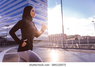 Muslim Urban Runner Training In The City Center. Beautiful Woman Doing Sport In The Early Morning