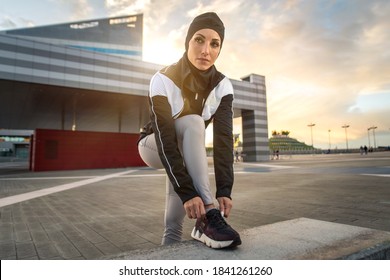 Muslim Urban Runner Training In The City Center. Beautiful Woman Doing Sport In The Early Morning