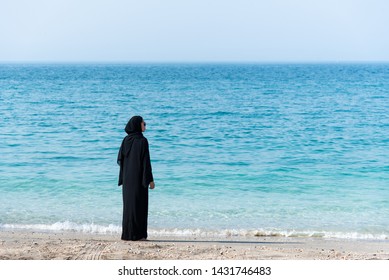 Muslim woman in abaya spending time by the seaside