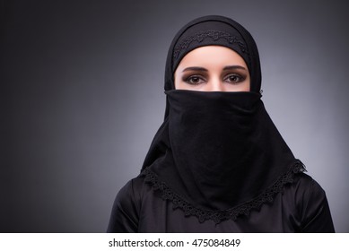 Muslim woman in black dress against dark background - Shutterstock ID 475084849