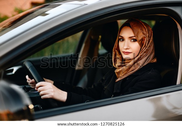 Muslim woman in car as driver. Arabic woman in hijab\
driving a car