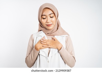 Muslim Woman Close Eyes Holding Chest While Feeling Relieved