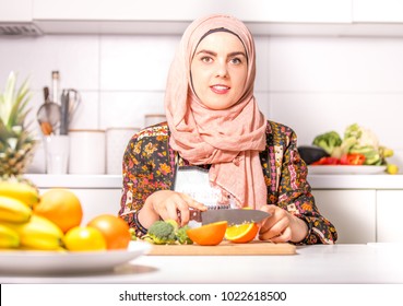 Muslim Woman Cooking In Kitchen. Arab Woman With Hijab.