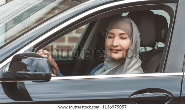 Muslim woman is driving a\
car